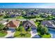 Expansive aerial view of a home with mature landscaping, a wide driveway, and a well-maintained lawn in a desirable community at 1338 Neuport Path, The Villages, FL 32163