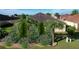Professionally landscaped backyard featuring decorative rock, flowering plants and manicured evergreens at 1338 Neuport Path, The Villages, FL 32163