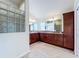 Bathroom boasts dual sinks, tile floors, and abundant cabinet storage with a window providing natural light at 1338 Neuport Path, The Villages, FL 32163