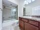 Bathroom with a tiled walk-in shower and vanity with a granite countertop at 1338 Neuport Path, The Villages, FL 32163