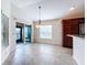 Dining area with sliding glass doors leading to outdoor space, next to a kitchen with stainless steel appliances at 1338 Neuport Path, The Villages, FL 32163