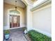 Inviting front porch featuring a decorative glass door, elegant planters, and a stylish tile floor at 1338 Neuport Path, The Villages, FL 32163