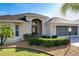 Charming single-story home featuring a beautiful front yard with manicured landscaping and a screened garage at 1338 Neuport Path, The Villages, FL 32163