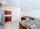 Open kitchen with granite countertops, stainless steel appliances, and tile flooring at 1338 Neuport Path, The Villages, FL 32163