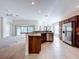 Open kitchen with stainless steel appliances, granite countertops, and a breakfast bar that overlooks the adjacent living area at 1338 Neuport Path, The Villages, FL 32163