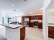 Modern kitchen featuring stainless steel appliances, dark wood cabinetry, and a breakfast bar with granite countertops at 1338 Neuport Path, The Villages, FL 32163