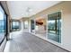 Enclosed patio with tiled floor, ceiling fan, multiple sliding glass doors and view to kitchen at 1338 Neuport Path, The Villages, FL 32163