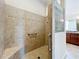 Tiled shower with glass block wall, built-in seat, grab bars, and handheld showerhead at 1338 Neuport Path, The Villages, FL 32163