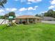 Expansive backyard featuring green lawn, playground and partial view of rear of house at 8830 Se 161St Pl, Summerfield, FL 34491