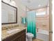 Bathroom featuring vanity with granite countertop, framed mirror, and bathtub with shower at 8830 Se 161St Pl, Summerfield, FL 34491