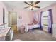 Comfortable bedroom with carpeted floors, a ceiling fan, and window with purple curtains at 8830 Se 161St Pl, Summerfield, FL 34491