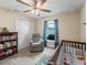 Cozy Bedroom with crib, rocker, and ample closet space for organized storage at 8830 Se 161St Pl, Summerfield, FL 34491