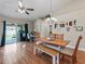 Bright dining area with wood flooring, a modern chandelier, and sliding door access to the patio at 8830 Se 161St Pl, Summerfield, FL 34491