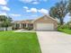 Inviting single-story home with a well-manicured lawn and a two-car garage, blending comfort and style at 8830 Se 161St Pl, Summerfield, FL 34491