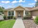 Close-up of the home's entrance with white columns, a decorative wreath, and manicured landscaping at 8830 Se 161St Pl, Summerfield, FL 34491