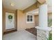 Covered front porch with stone accents, a white door, and decorative wreath for a welcoming entry at 8830 Se 161St Pl, Summerfield, FL 34491