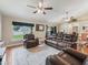 Comfortable living room featuring leather sofas, a ceiling fan, and views of the backyard at 8830 Se 161St Pl, Summerfield, FL 34491