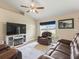 Cozy living room featuring a fireplace, large TV, comfortable seating, and a view of the backyard at 8830 Se 161St Pl, Summerfield, FL 34491