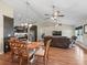 Open concept living room, dining area and kitchen with ceiling fans and wood flooring at 8830 Se 161St Pl, Summerfield, FL 34491