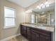 Modern main bathroom featuring a glass enclosed shower, double sink vanity, and window at 8830 Se 161St Pl, Summerfield, FL 34491