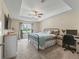 Bright main bedroom with large window, ceiling fan, and ensuite bathroom at 8830 Se 161St Pl, Summerfield, FL 34491