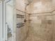 Elegant bathroom with tiled shower, built-in shelving, and brushed nickel hardware at 8830 Se 161St Pl, Summerfield, FL 34491