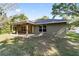 A peaceful backyard view with a covered patio and lush green lawn at 8566 Se 156Th Pl, Summerfield, FL 34491