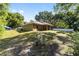 Expansive backyard featuring lush greenery, a gas tank, and a serene view of the property's rear exterior at 8566 Se 156Th Pl, Summerfield, FL 34491