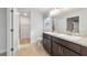 Bright bathroom with double sink vanity featuring granite countertop and a tiled shower at 8566 Se 156Th Pl, Summerfield, FL 34491