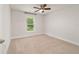 This bedroom is spacious with plush carpet, a ceiling fan, and natural light from the window at 8566 Se 156Th Pl, Summerfield, FL 34491