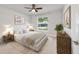 Comfortable bedroom with a cozy bed, a neutral color palette, and a large window overlooking the outdoors at 8566 Se 156Th Pl, Summerfield, FL 34491