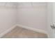 The walk-in closet is carpeted and equipped with shelves and closet rod for efficient storage at 8566 Se 156Th Pl, Summerfield, FL 34491