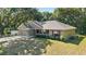 Well-maintained single story home with a lush green lawn and mature trees, featuring a covered front porch at 8566 Se 156Th Pl, Summerfield, FL 34491