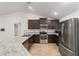 Modern kitchen with stainless steel appliances, and dark wood cabinetry and granite counters at 8566 Se 156Th Pl, Summerfield, FL 34491