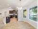 Modern kitchen with stainless steel appliances, granite countertops, and breakfast nook with many windows at 8566 Se 156Th Pl, Summerfield, FL 34491