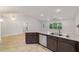 Open concept kitchen and living space with wood-look tile floors and granite island at 8566 Se 156Th Pl, Summerfield, FL 34491