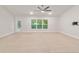 This bright living room has a ceiling fan, large windows, and a sliding glass door at 8566 Se 156Th Pl, Summerfield, FL 34491