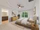 Cozy main bedroom with tray ceilings, ceiling fan, and bathroom access at 8566 Se 156Th Pl, Summerfield, FL 34491