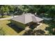 An aerial view of the rear exterior, showing the covered back patio and mature tree coverage at 8566 Se 156Th Pl, Summerfield, FL 34491
