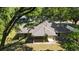Aerial view of the rear exterior showing the back patio and mature trees providing ample shade at 8566 Se 156Th Pl, Summerfield, FL 34491