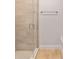 The bathroom features a glass-enclosed shower with wood-look tiling and a neutral color scheme at 8566 Se 156Th Pl, Summerfield, FL 34491