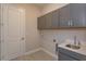 Laundry room with gray cabinets and utility sink at 10142 Ballast Dr, Orlando, FL 32827