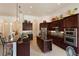 Kitchen with granite countertops, dark wood cabinets, and stainless steel appliances at 5414 Meadow Hill Loop, Lady Lake, FL 32159