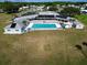 Aerial view of clubhouse with community pool, surrounded by well-maintained lawn and parking area at 1209 Apache Cir, Tavares, FL 32778