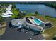 Aerial view of community clubhouse with sparkling pool, ample parking, and a tranquil lake at 1209 Apache Cir, Tavares, FL 32778