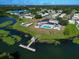 Aerial view of clubhouse with sparkling pool, shuffleboard, and access to a beautiful lake at 1209 Apache Cir, Tavares, FL 32778