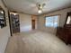Cozy bedroom with neutral carpet, ceiling fan, and a window with blinds at 1209 Apache Cir, Tavares, FL 32778