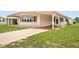 Single-wide manufactured home with carport and well-maintained lawn at 1209 Apache Cir, Tavares, FL 32778