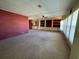 Bright living room featuring neutral carpet, ceiling fan, and large windows at 1209 Apache Cir, Tavares, FL 32778