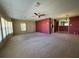 Open living room with neutral carpet, ceiling fan, and ample natural light at 1209 Apache Cir, Tavares, FL 32778